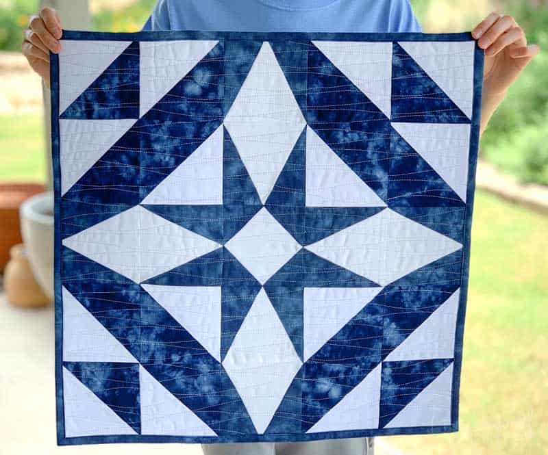 Get this free quilt pattern called The Midnight Star Table Topper. #freequiltpattern #beginnerquilting #sewingtip