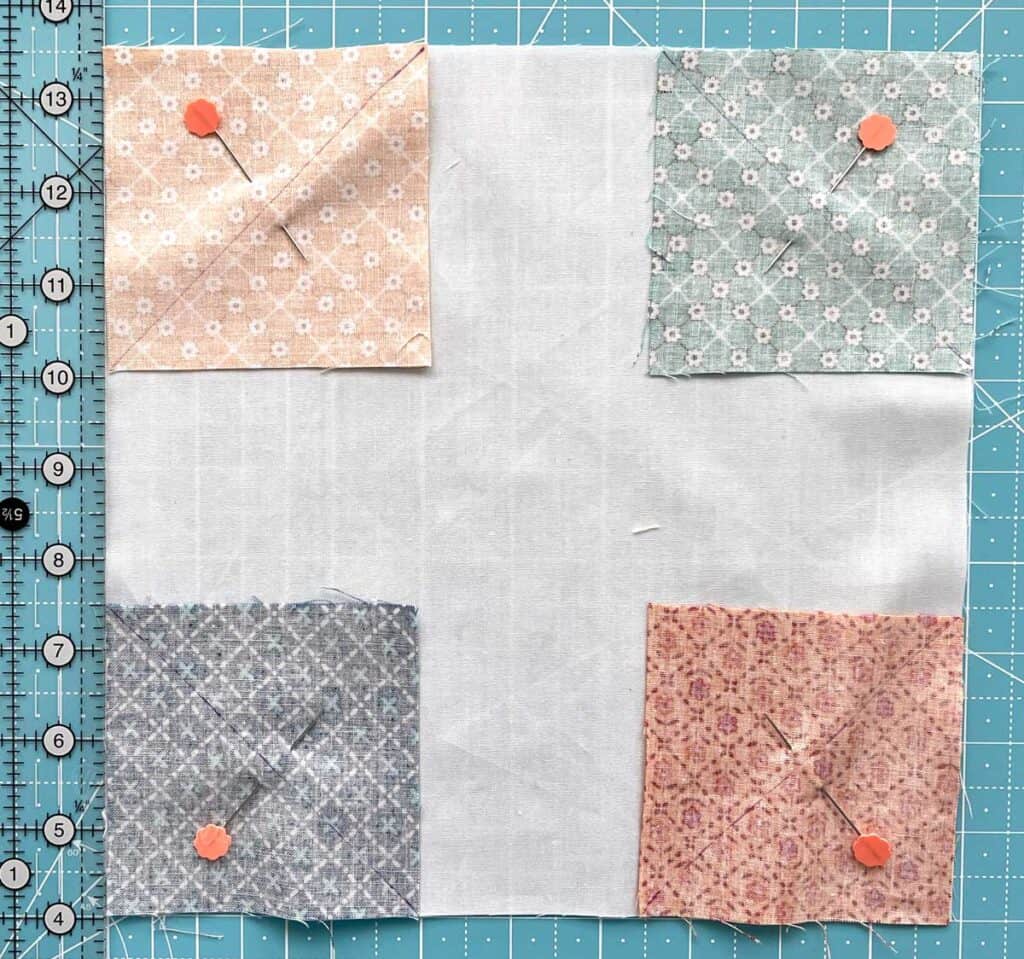 Snowball quilt block with squares pinned in each corner.